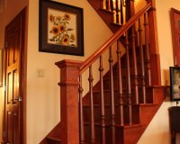 Custom maple staircase with box newels with turned wooden balusters and return miter treads
